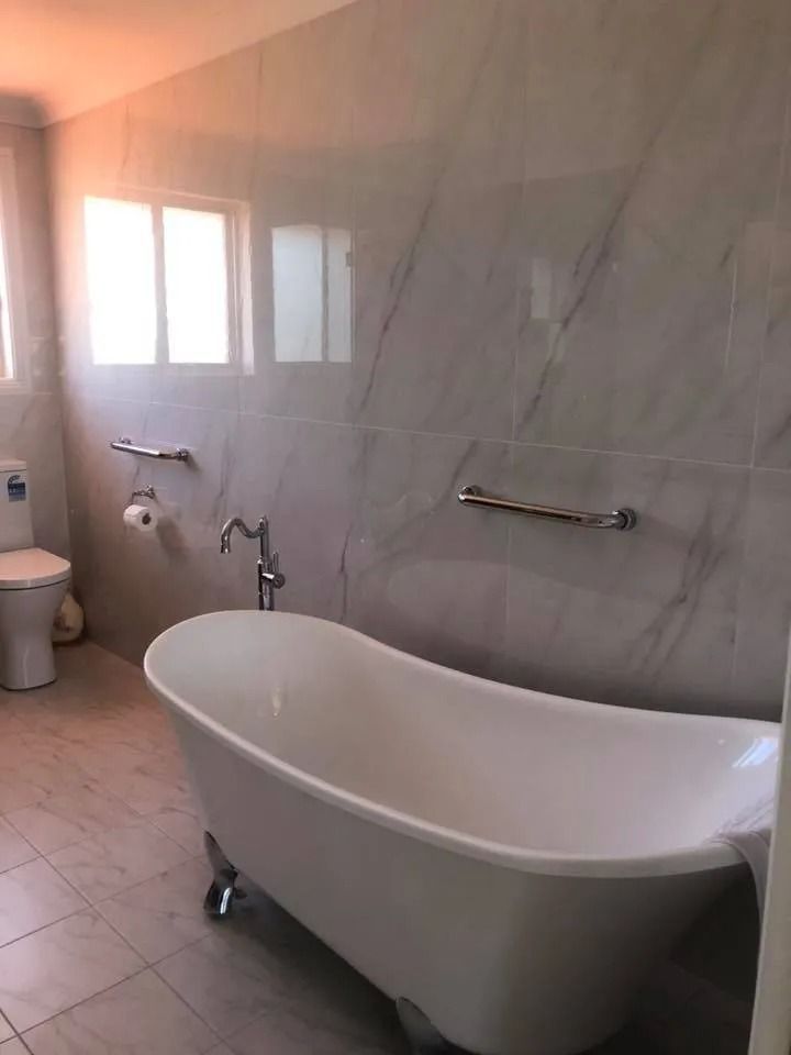 Bathroom With White Clawfoot Tub, Toilet, and Silver Fixtures — Alcando Renovations and Maintenance In Bobin, NSW