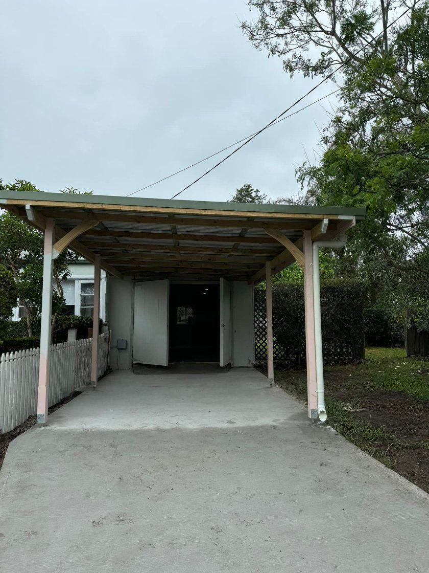 Carport With Cement Driveway, White Building With Open Door — Alcando Renovations and Maintenance In Bobin, NSW