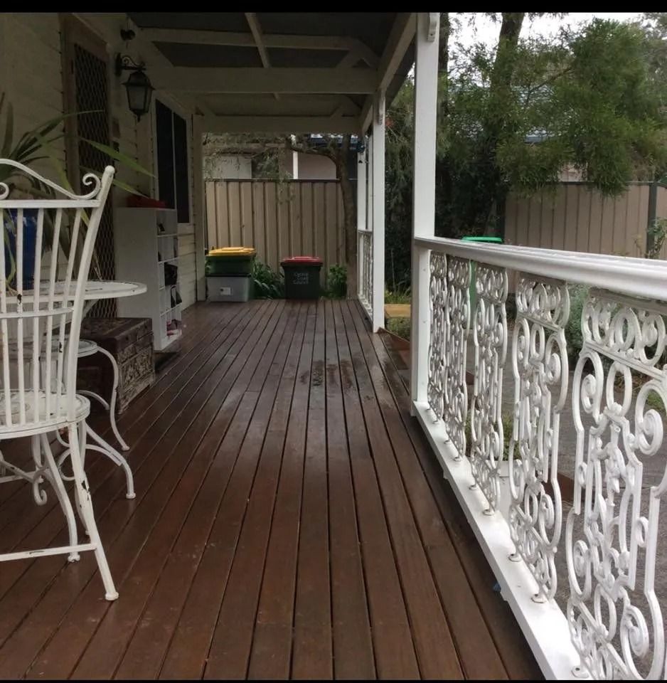 Covered Wooden Porch With Ornate White Railing and Seating — Alcando Renovations and Maintenance In Bobin, NSW