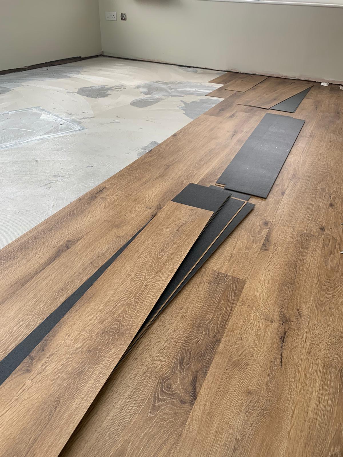 A wooden floor is being installed in a room.