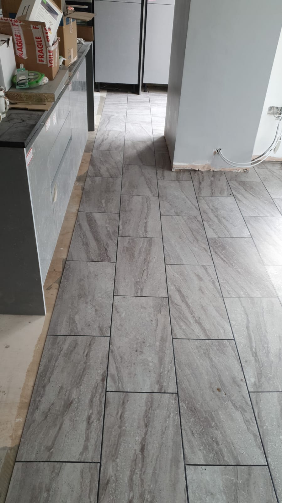 A kitchen with a tiled floor and a marble counter top.