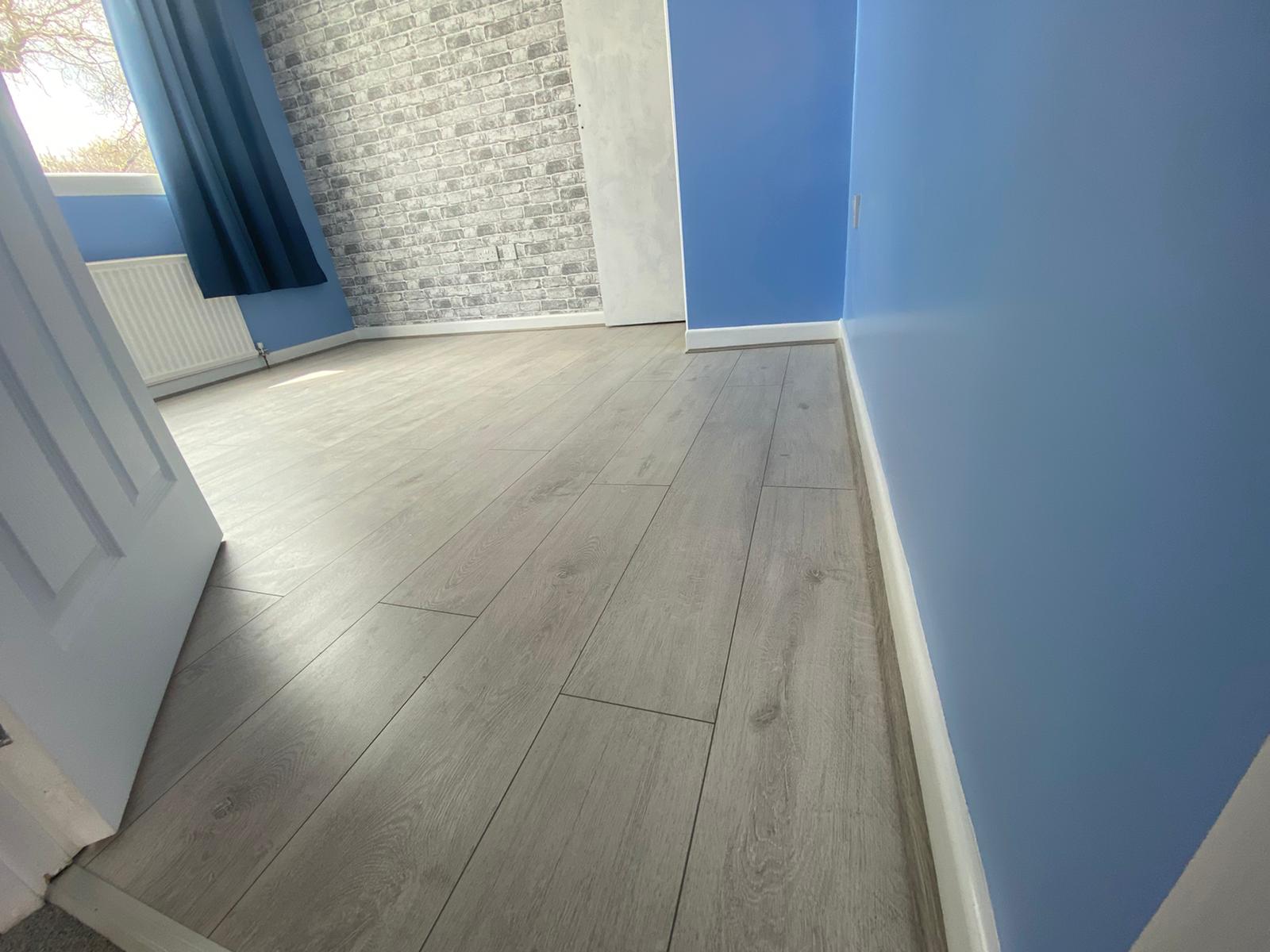 A room with blue walls and a white wooden floor.