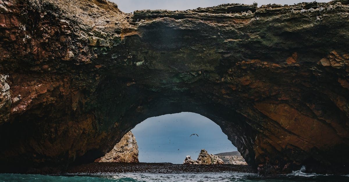 A large rock arch overlooking a body of water.
