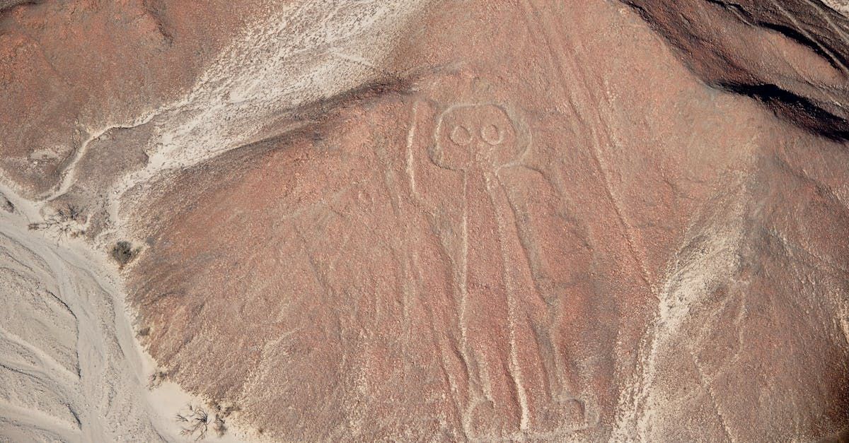 An aerial view of a desert landscape with a drawing of a person in the sand.
