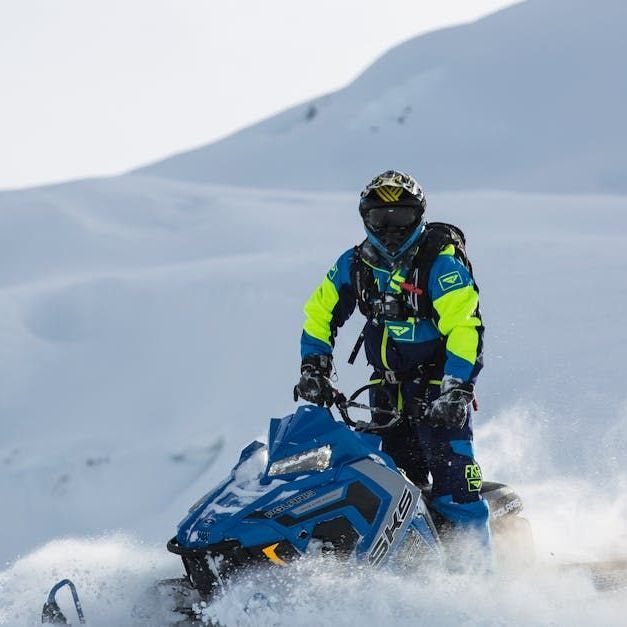 A man is riding a snowmobile in the snow