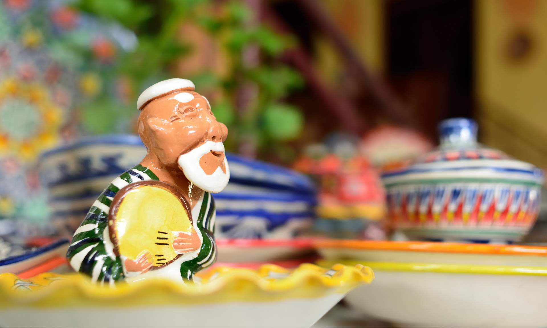 A figurine of a man with a beard is sitting in a bowl.