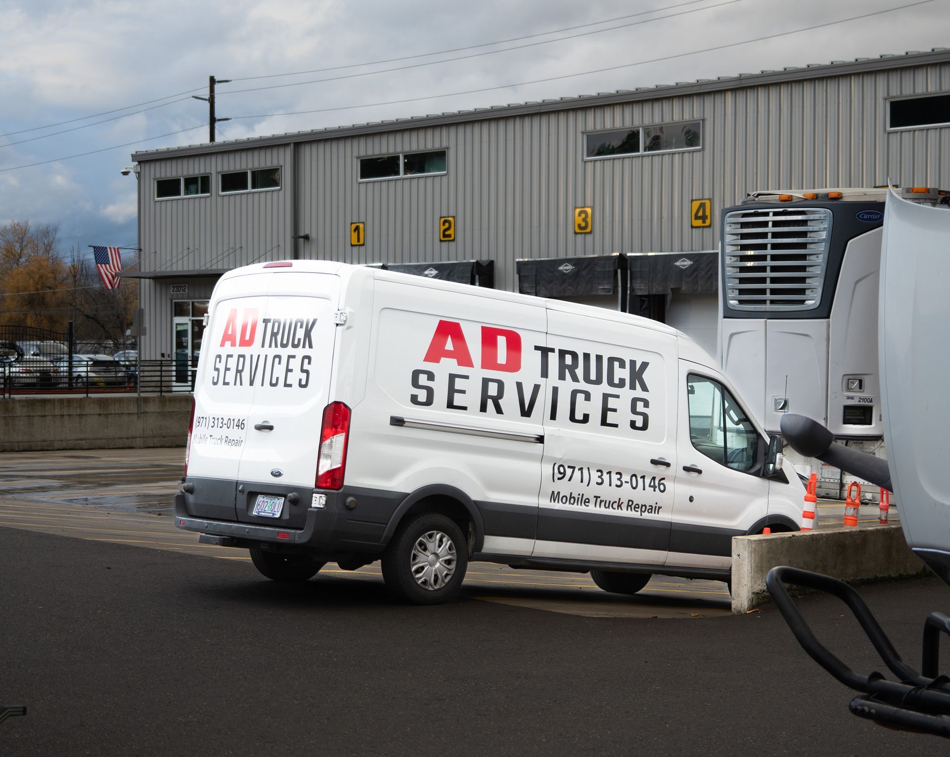 Technician inspecting equipment inside an open utility truck in a workshop garage