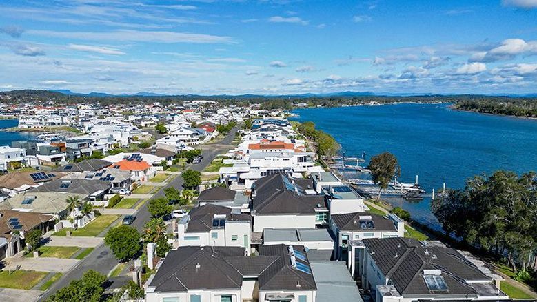 An Aerial View Of A River Surrounded By Trees And Houses — DCK Concreting In Port Macquarie, NSW