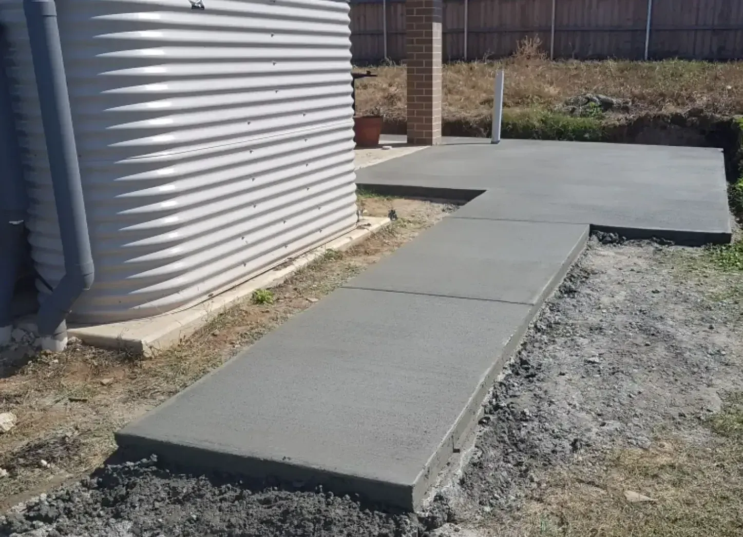 A Concrete Walkway Is Being Built In A Backyard — DCK Concreting In Lake Cathie, NSW