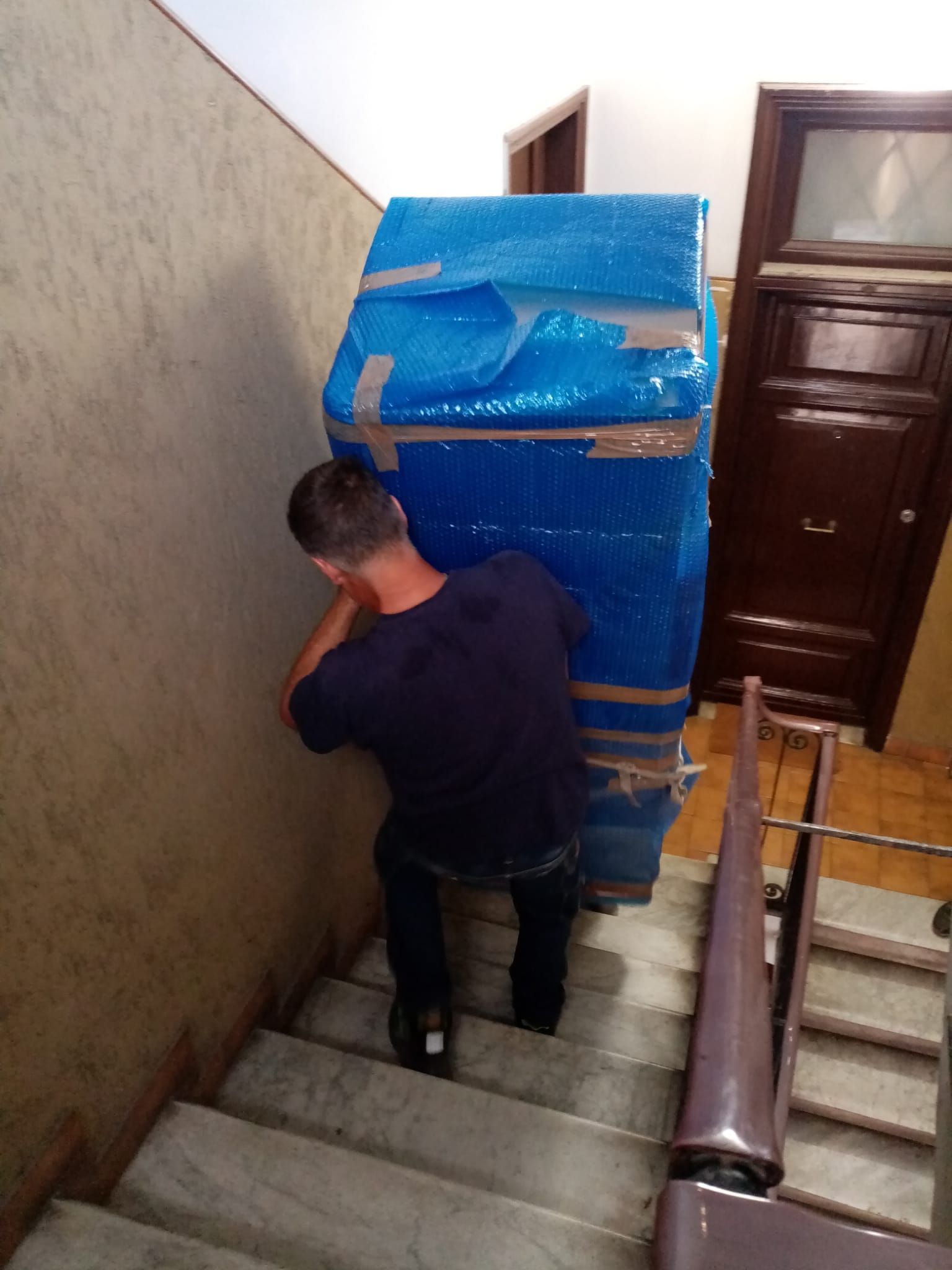 Trasporto degli scatoloni sulle scale del palazzo per trasloco di un appartamento