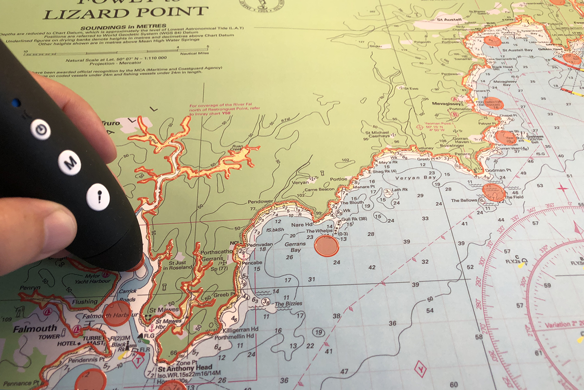 A picture of one of the talking and touchable charts produced by Imray available from SVT. The chart is of Southern Cornwall. A talking pen is being held on one of the descriptive spots.