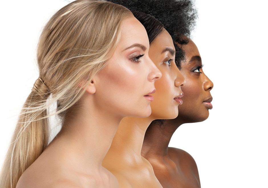 Three women in side profile with varied skin tones against a white background