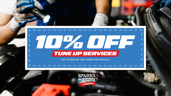 Coupon: 10% off tune-up services at Sparks Automotive. Mechanic working on car engine. Blue and red text.