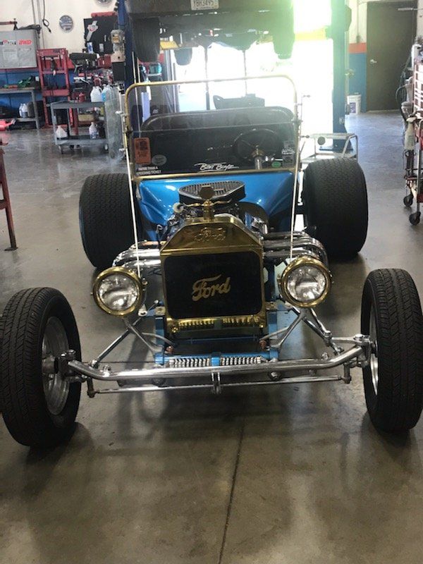 Blue hot rod with chrome details in a garage.