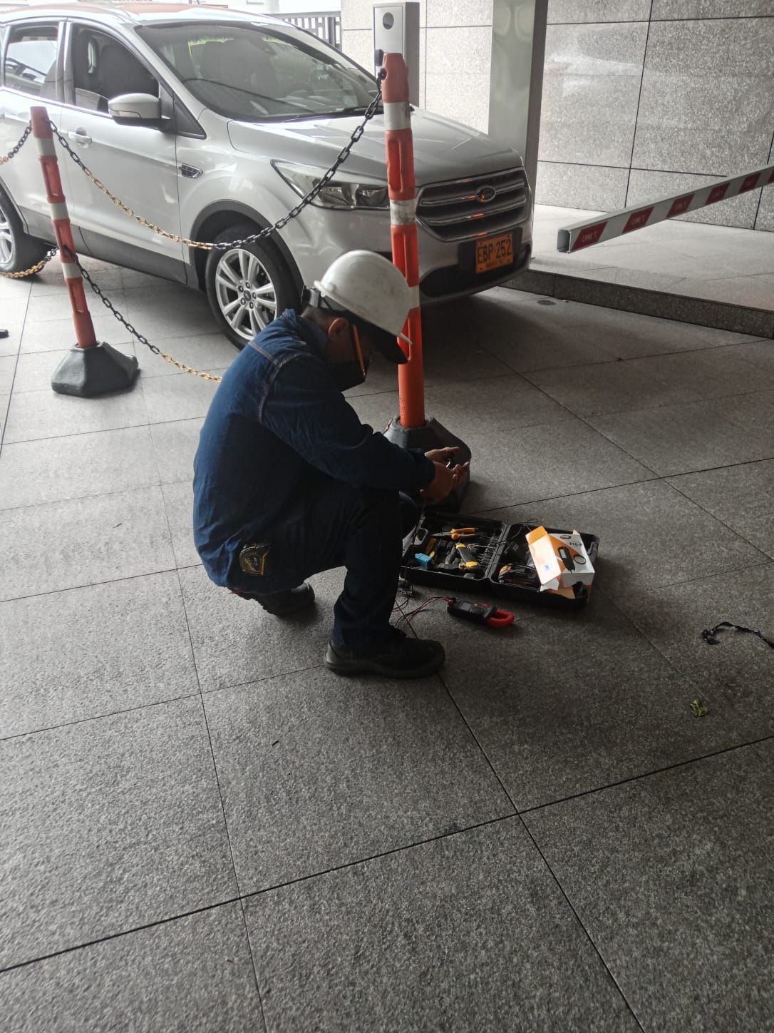 Un trabajador se agacha junto a una bolsa de herramientas iluminada