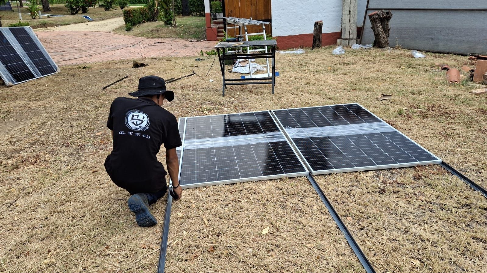 Un trabajador se arrodilla junto a unos paneles solares