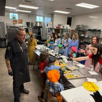 Chef teaching children to serve food at a cafeteria counter