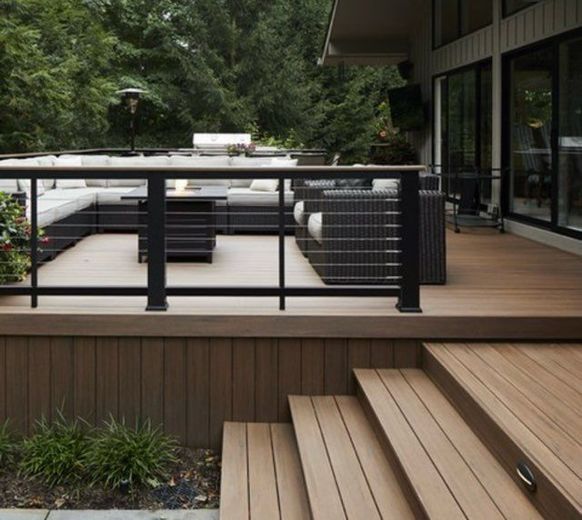 A wooden deck with stairs and a black railing