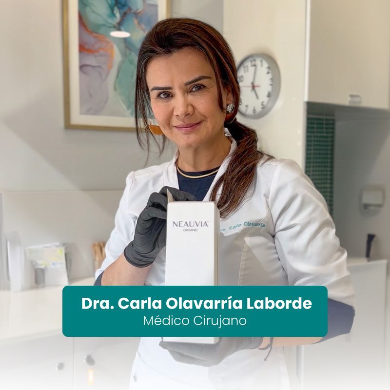 Doctora Carla Olavarria sosteniendo una caja de NEAUVIA en una clínica luminosa, con su nombre y cargo a la vista.