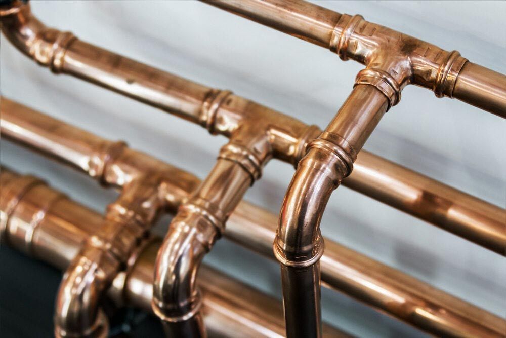 A Close Up of a Bunch of Copper Pipes on a Table — Rock Plumbing & Gasfitting In Cannonvale, QLD