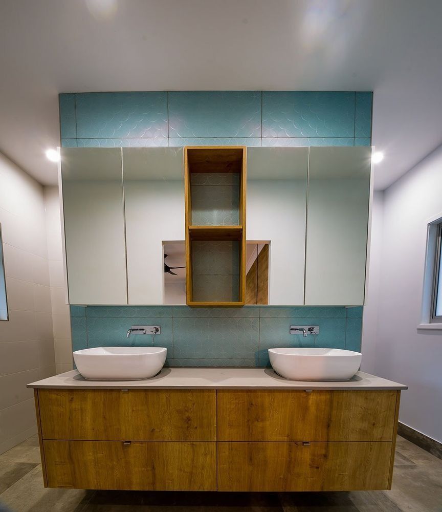 A Bathroom With Two Sinks and a Large Mirror — Rock Plumbing & Gasfitting In Cannonvale, QLD