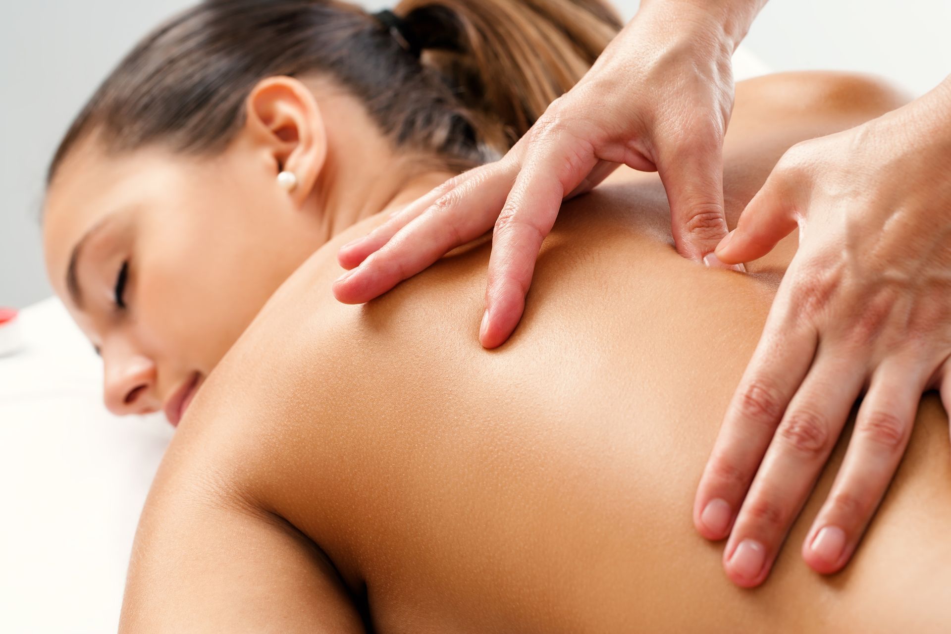 Therapist performing a back session, showcasing expert care, highlighting therapeutic massage.