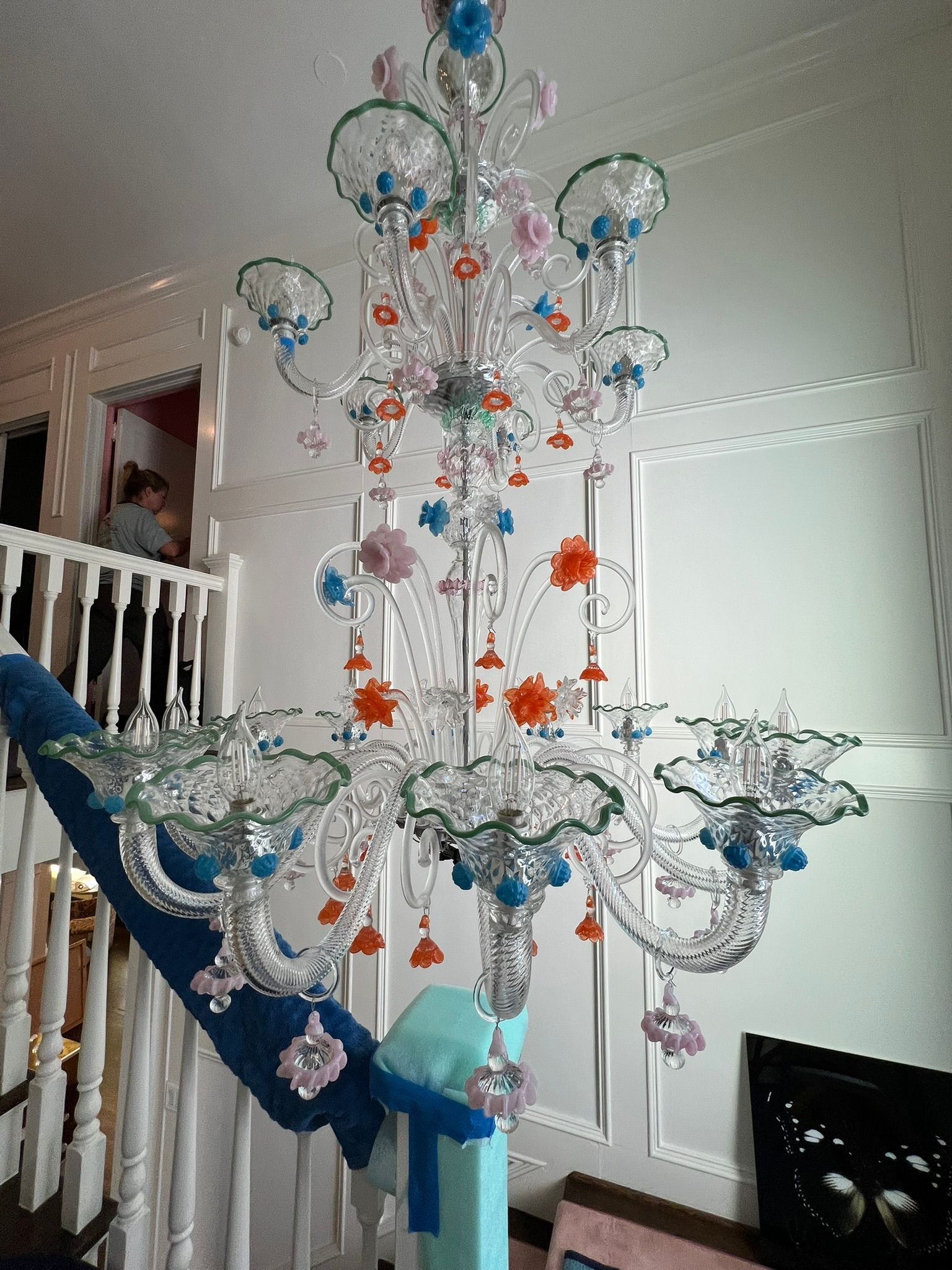 Blue-and-white hanging crystal decoration in a bright room, with orange accents and a staircase nearby