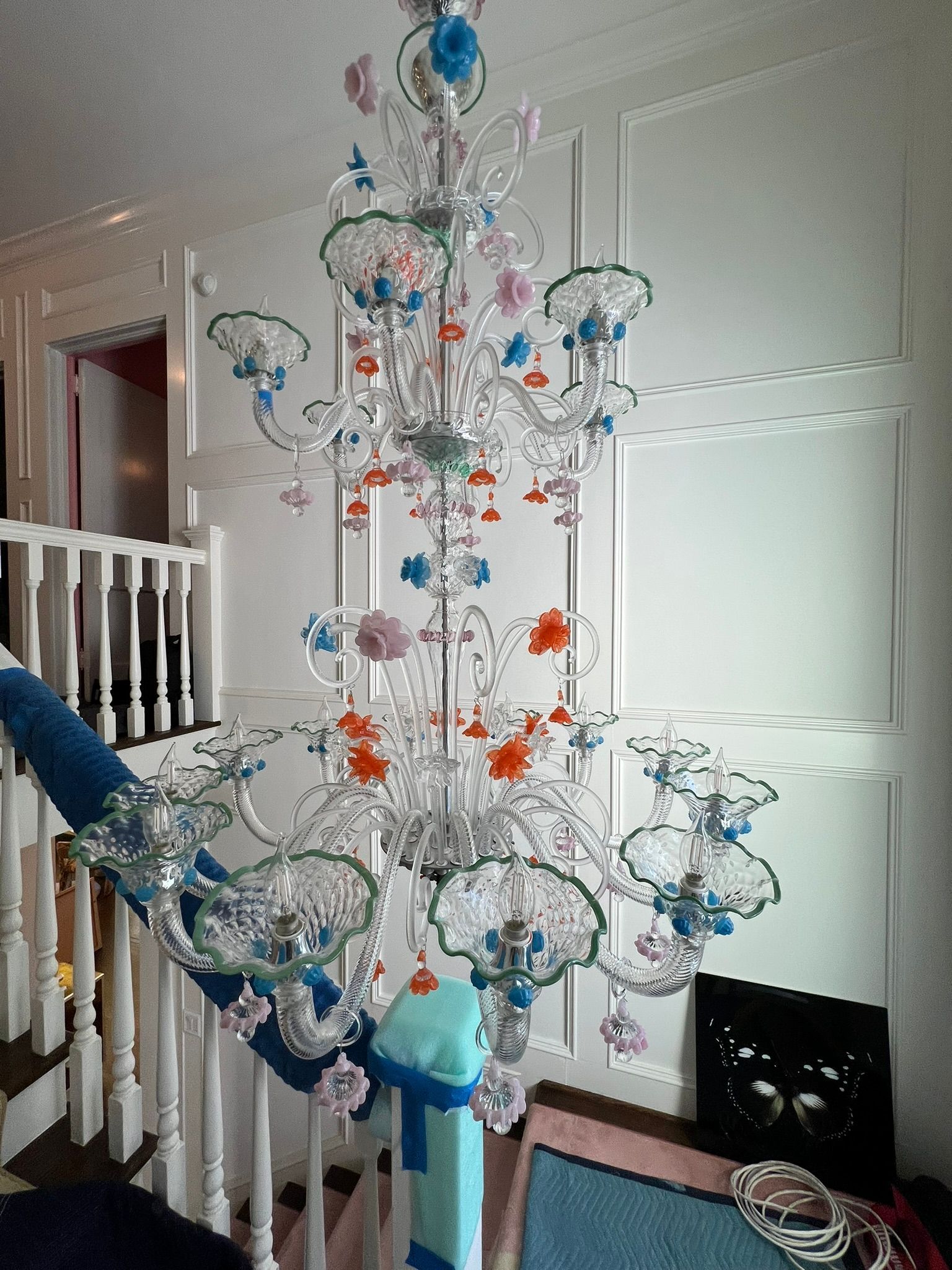 Colorful hanging bead chandelier displayed in a white staircase hallway