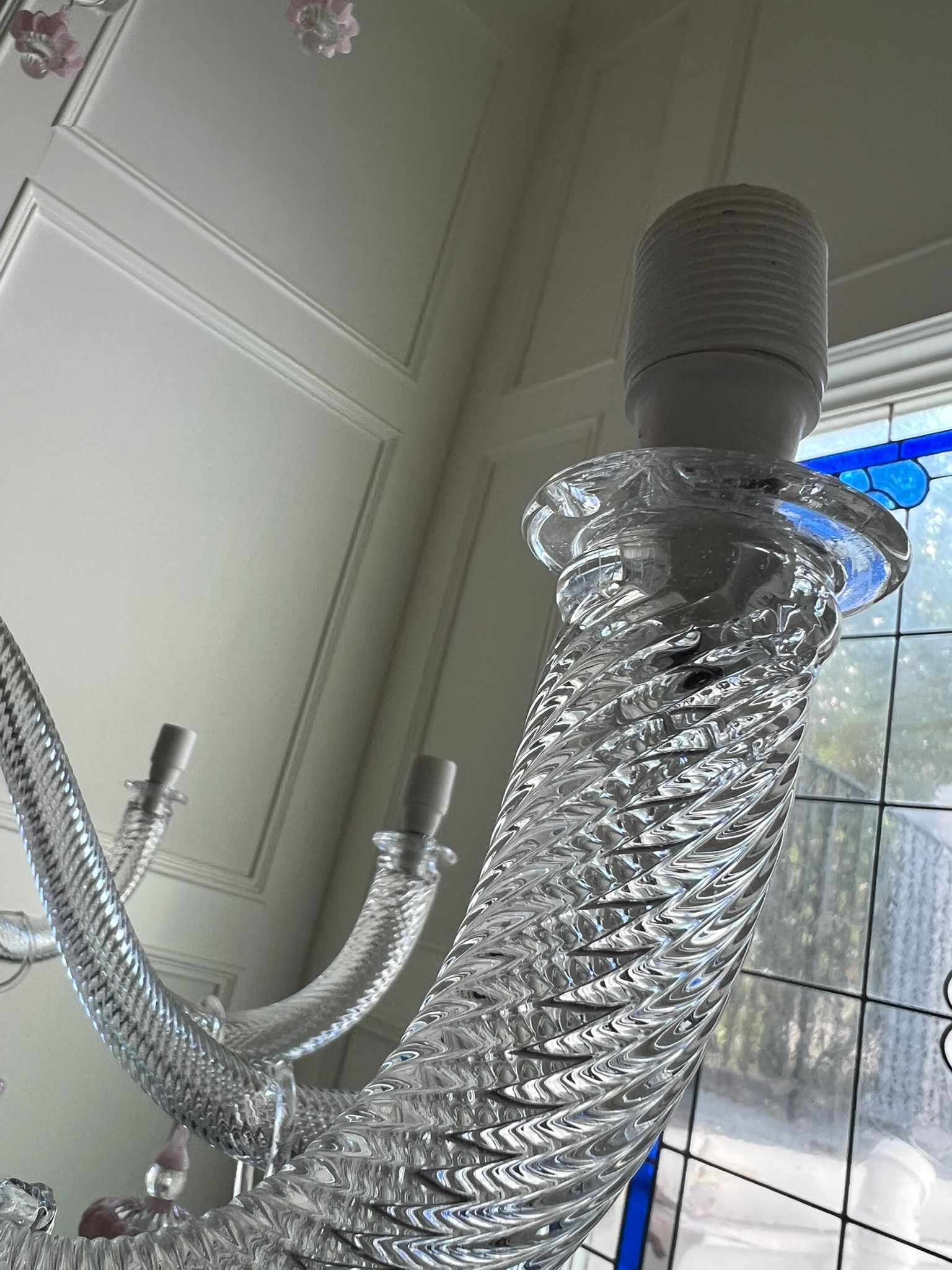 Two flexible silver ventilation hoses connected to a white ceiling vent in a bright room.