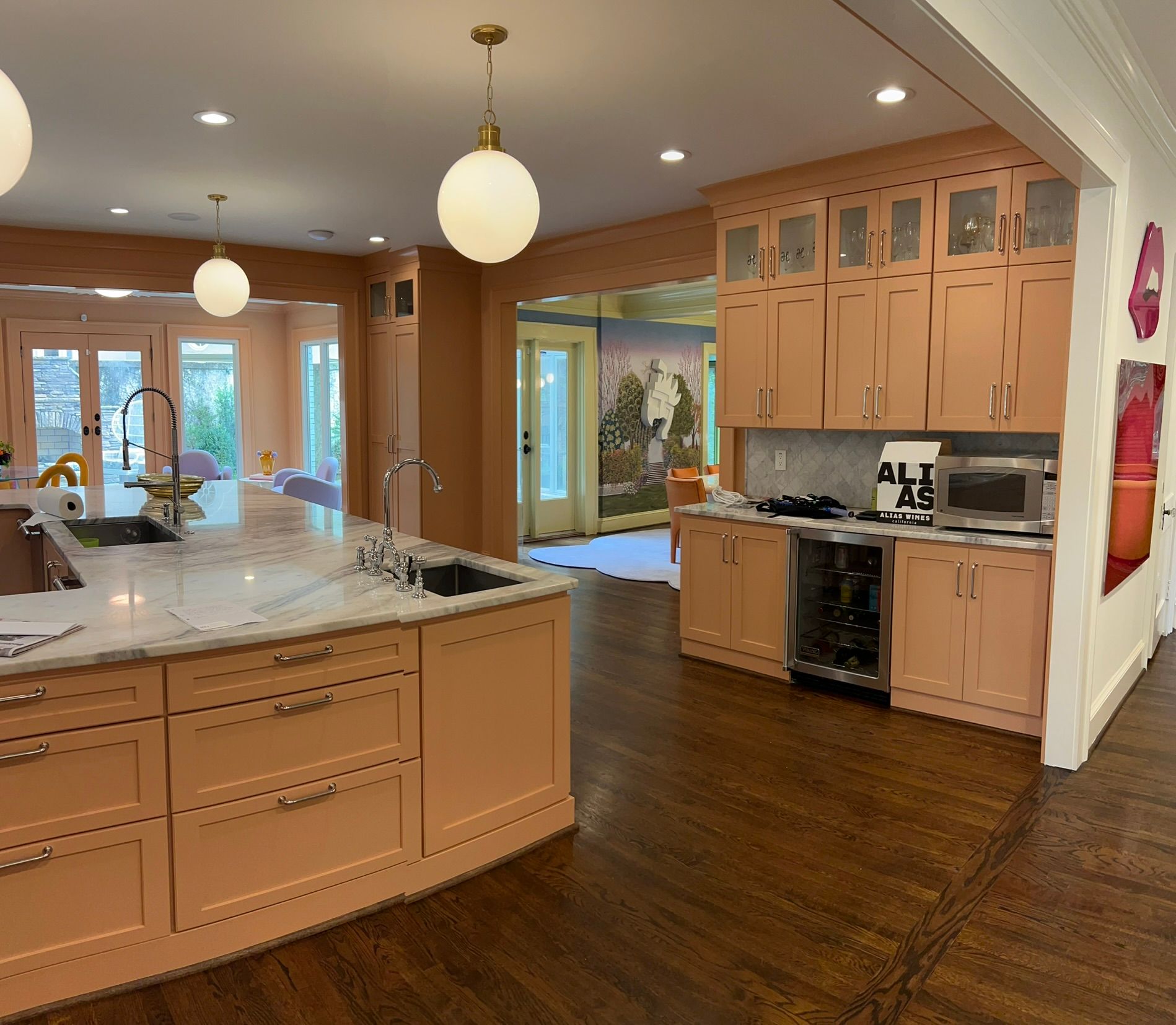 Spacious modern kitchen with wood cabinets, granite island, pendant lights, and hardwood floors