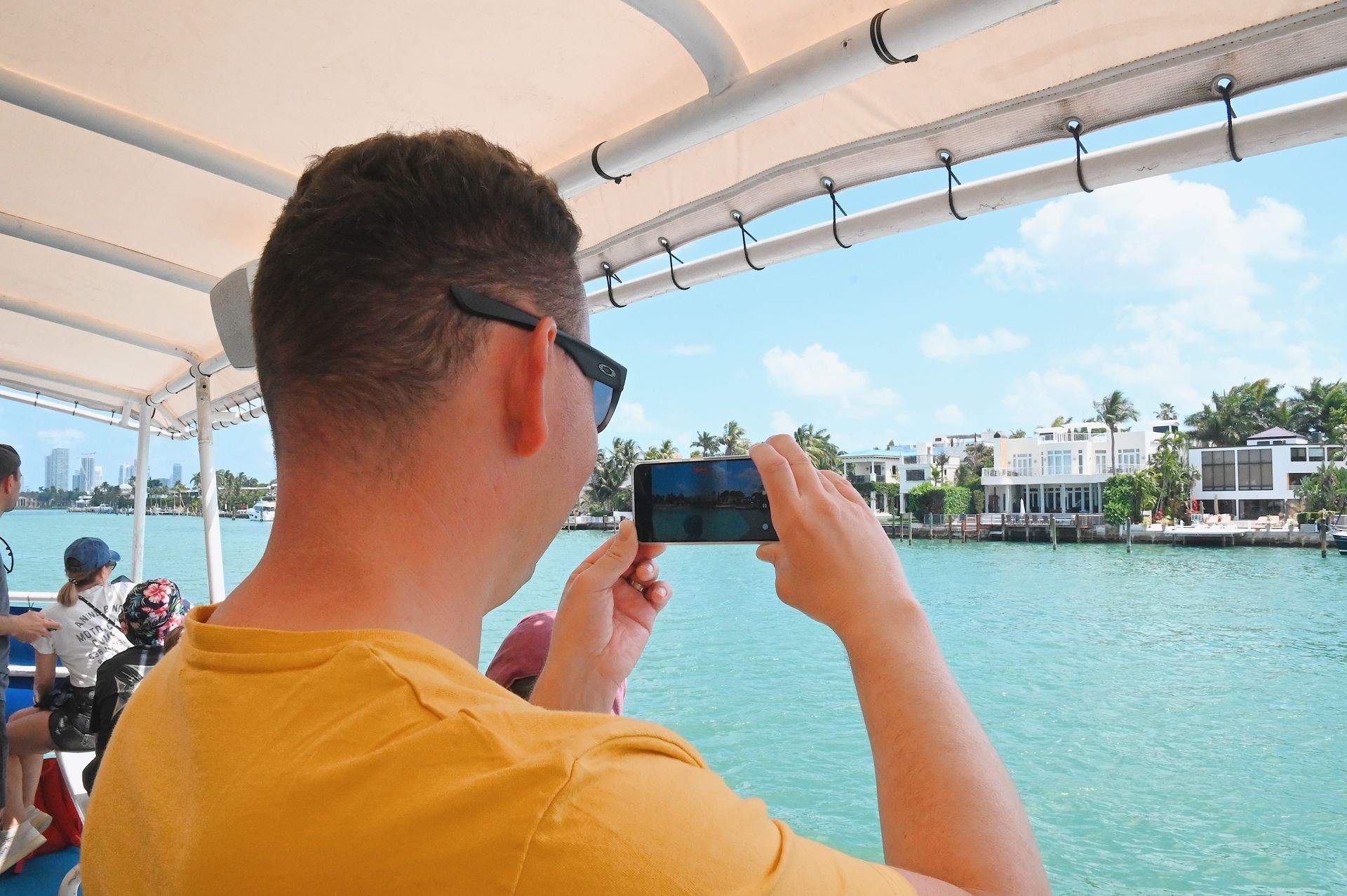 Guest taking pictures of Mansions in Star Island on boat tour of Celebrity Mansions, 