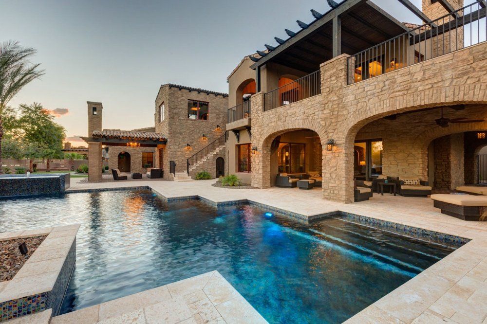 A large house with a large swimming pool in front of it.