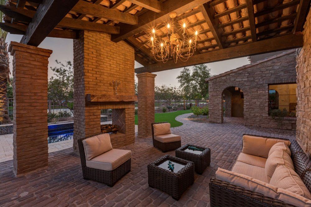There is a chandelier hanging from the ceiling of the patio area.