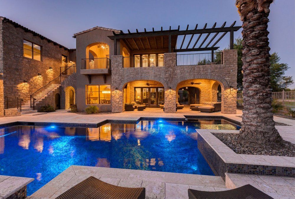 A large house with a swimming pool in front of it