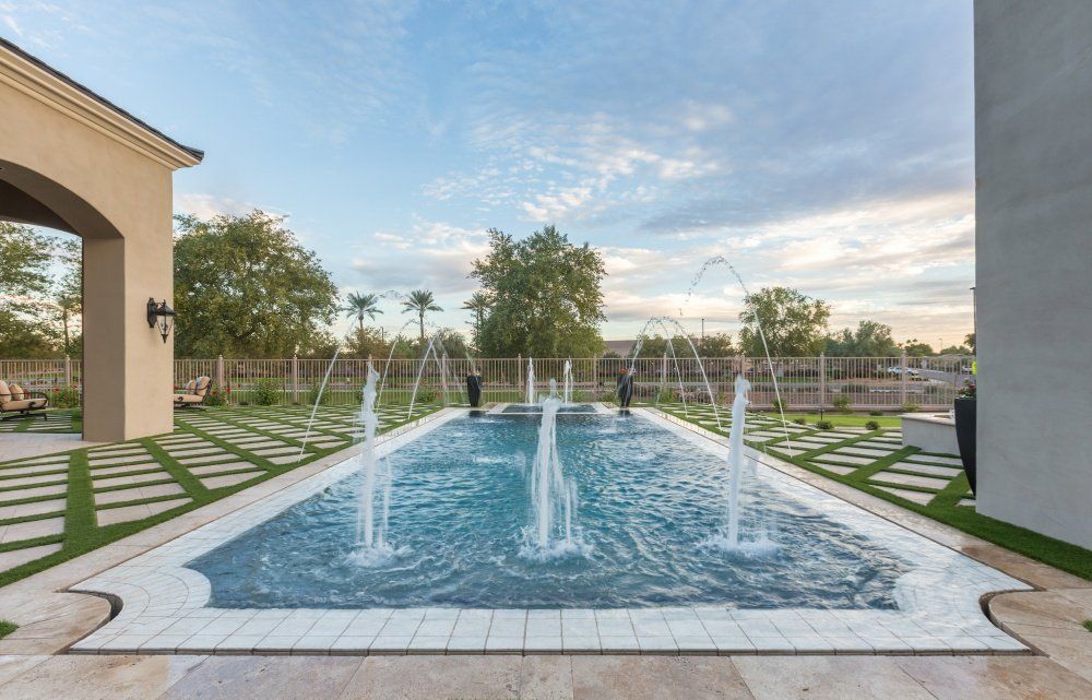 A large swimming pool with a fountain in the middle of it.