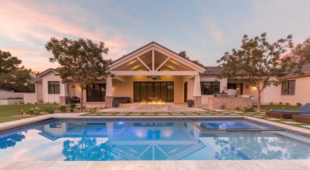 A large house with a large swimming pool in front of it.