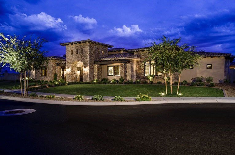 A large house with a lot of windows is lit up at night.
