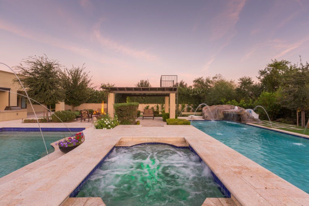 A large swimming pool with a hot tub in the middle of it.
