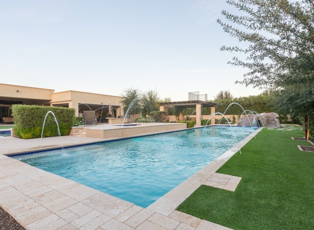 A large swimming pool with a fountain in the middle of it
