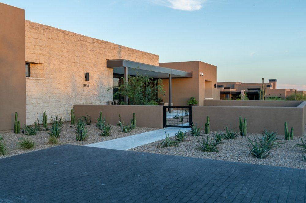 A large house with a lot of plants in front of it.