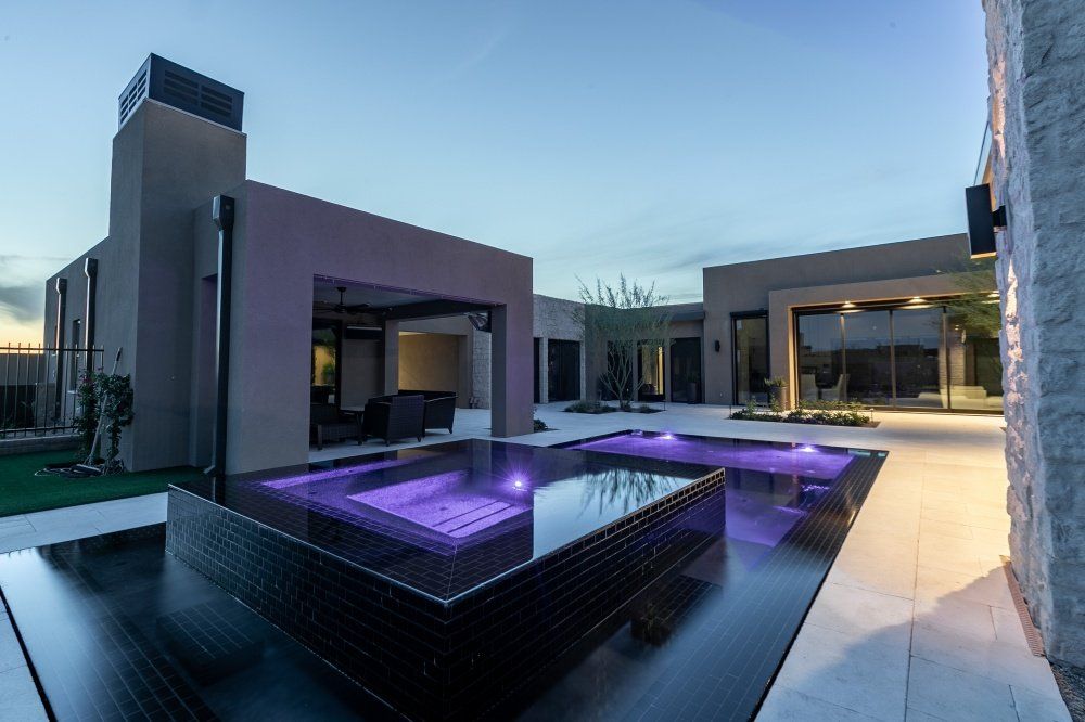 A large house with a purple pool in front of it.