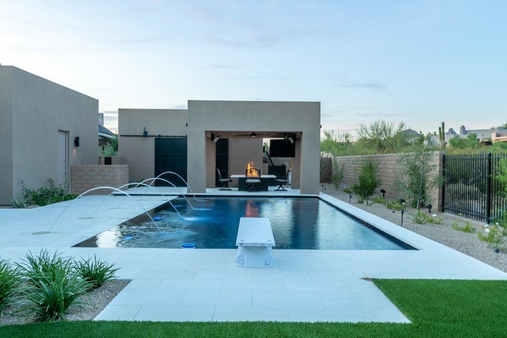There is a large swimming pool in the backyard of a house.