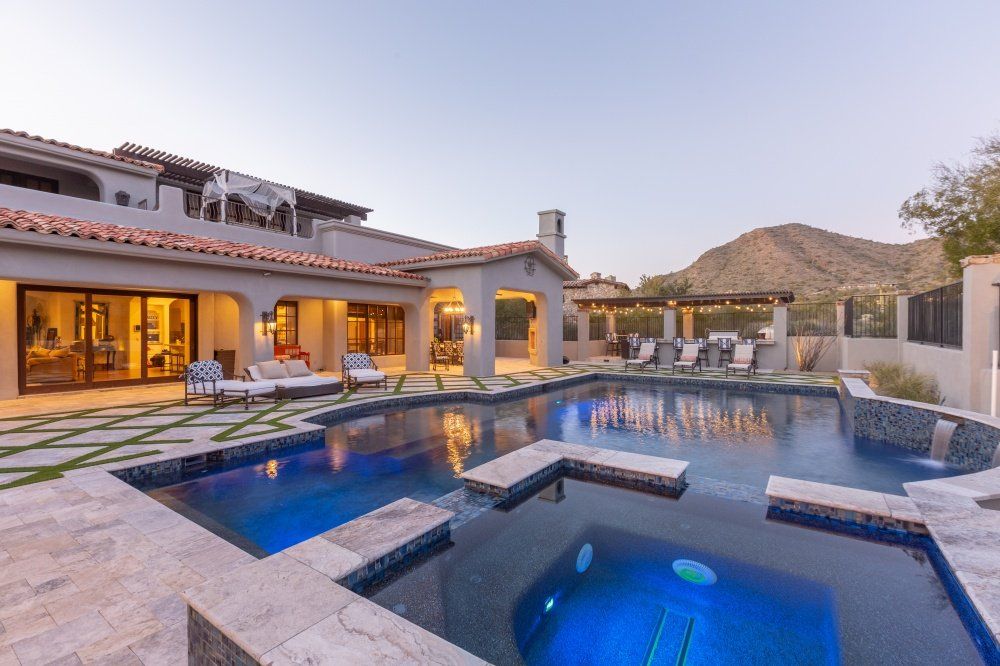 There is a large swimming pool in the backyard of a house.
