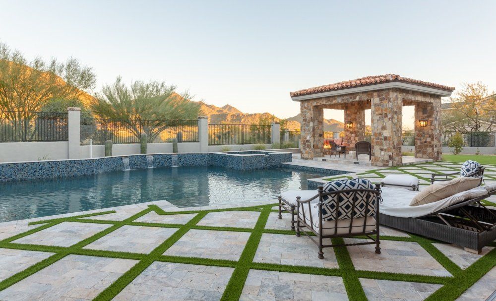 A large swimming pool with a gazebo in the backyard.