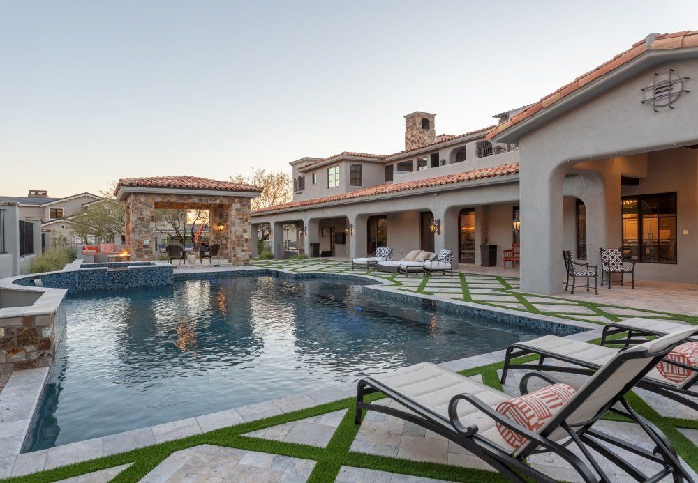 A large house with a large swimming pool in front of it