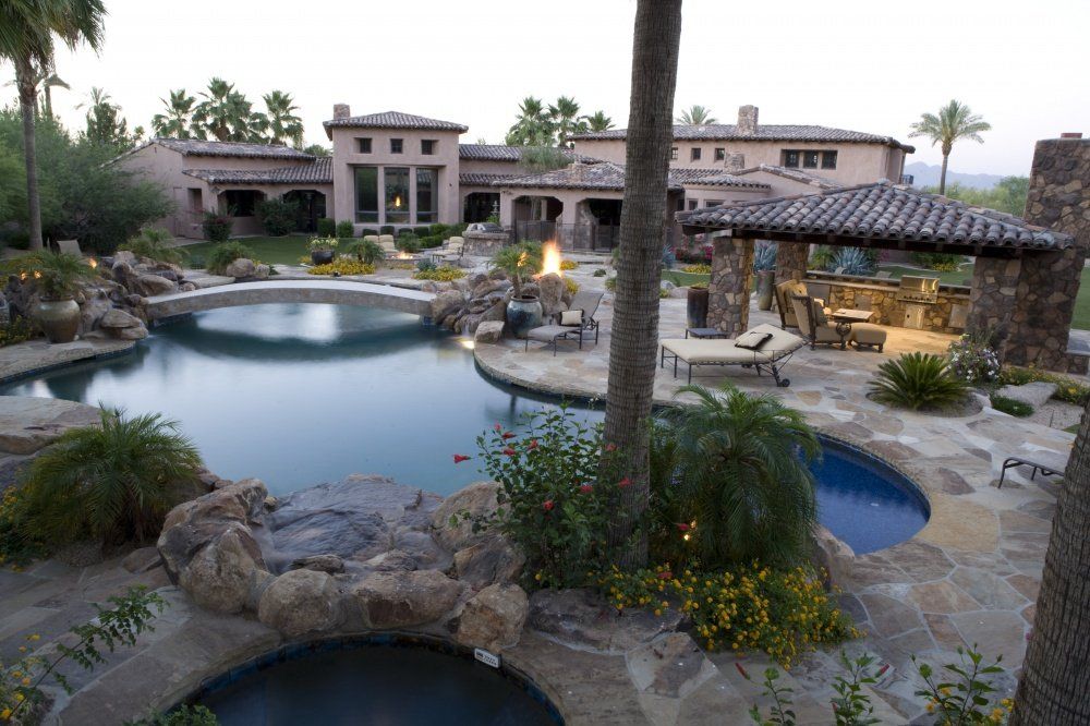 A large house with a large swimming pool in front of it