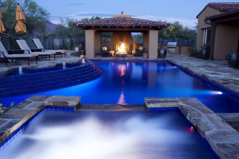 A large swimming pool with a fireplace in the middle of it