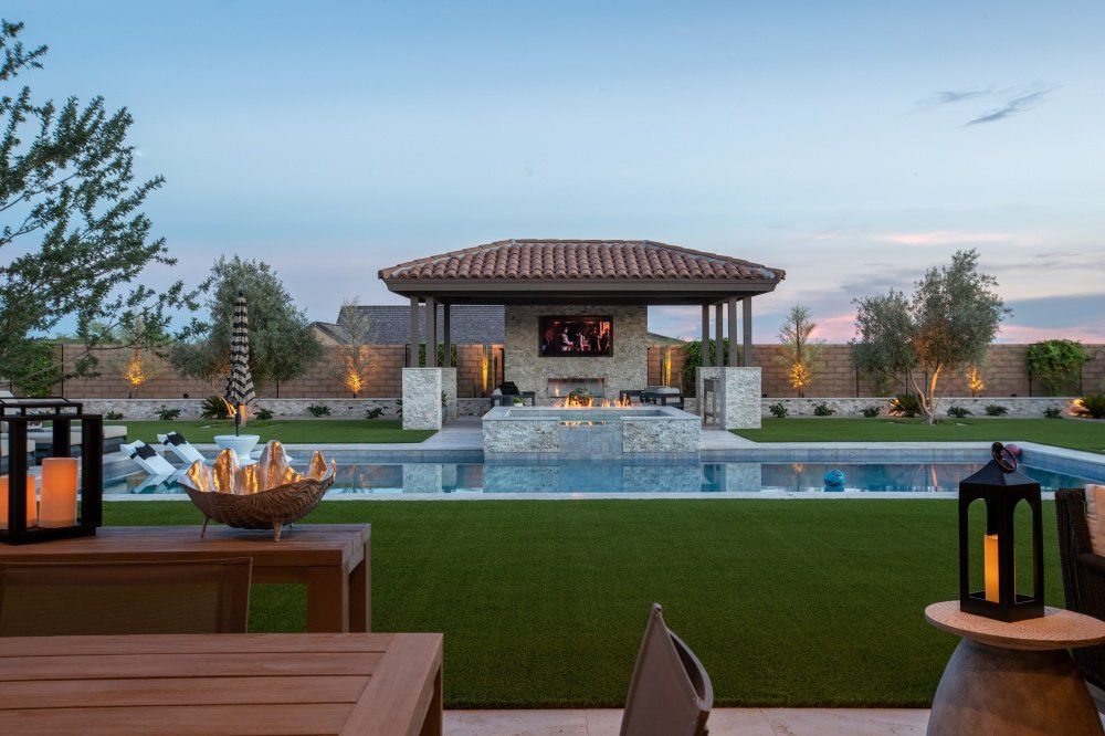 There is a large swimming pool in the backyard of a house.