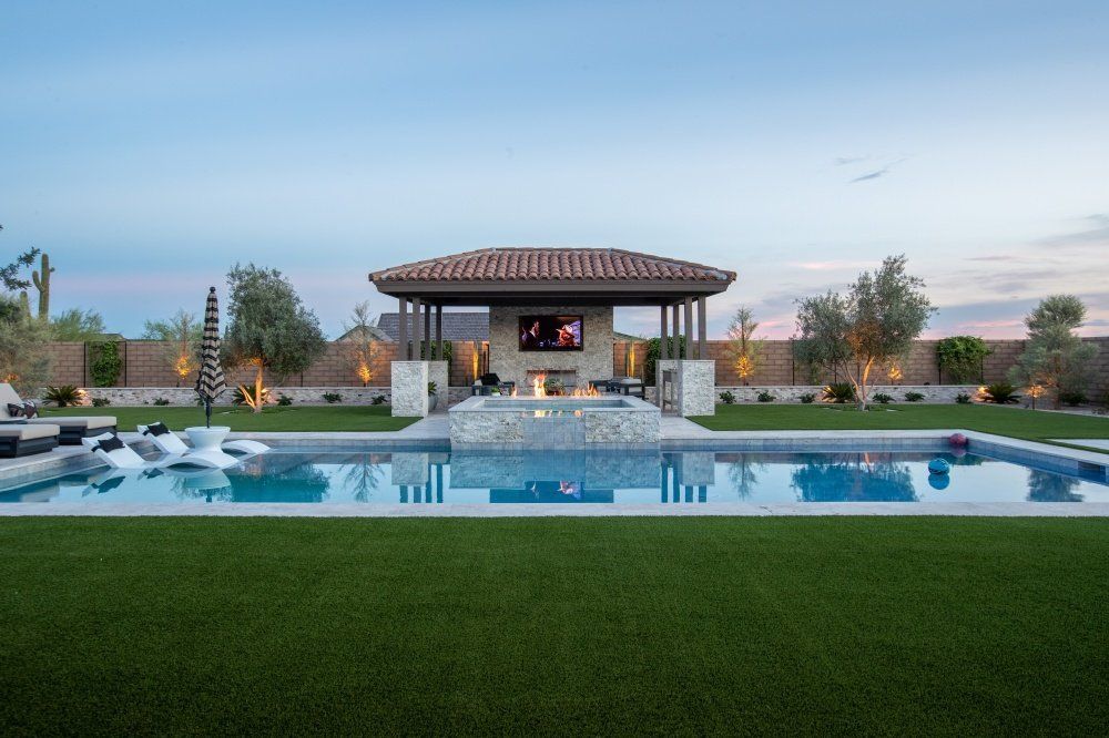 There is a large swimming pool in the backyard of a house.