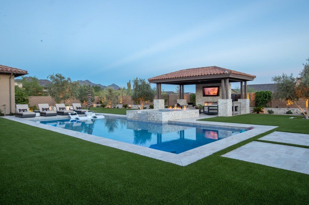 There is a large swimming pool in the backyard of a house.